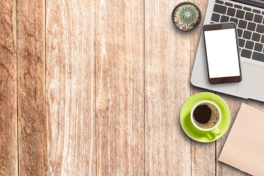 Modern ahşap ofis Resepsiyon Masa laptop, akıllı telefon, fincan kahve ve malzemeleri. Kopya alanı için herhangi bir tasarım ile Üstten Görünüm