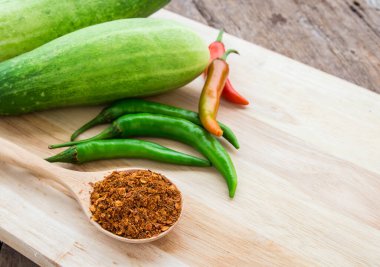 Biber tozu ve ahşap masa arka plan üzerinde kesme tahtası üzerinde taze biber