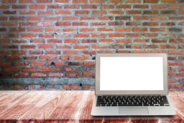 Bulanık tuğla duvar arka plan ile ahşap raflar boş ekran laptop. Görünümünde, ürün montaj koymak. İş kavramı.