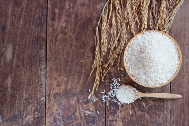 Eski ahşap masa arka plan kopya alanı ile kase ve çeltik pirinç yasemin pirinç