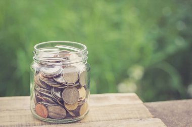 Filtre etkisi retro vintage tarzı ahşap tablo kavanoza para. Para ve iş kavramı