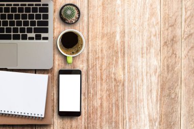 Modern ahşap ofis Resepsiyon Masa laptop, smartphone, fincan kahve ve malzemeleri. Kopya alanı için herhangi bir tasarım ile Üstten Görünüm