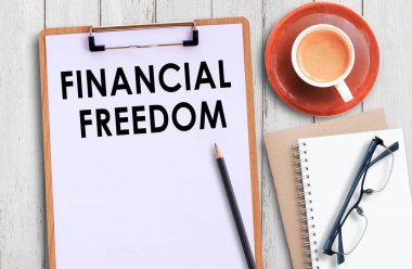 Not panosu, finansal özgürlük ve bir fincan kahve, ofis işyerindeki beyaz tahta masa üzerine kalem..