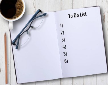 Not defterlerine bir fincan kahve, bardak ve kalemle listelemek için ofis işyerindeki ahşap masaya yazı yazmak.