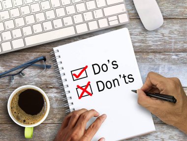 El yazısı Do 'lar, not defteri, klavye, kahve ve bardaklar ofis işyerindeki ahşap masada. İş ve eğitim kavramı fikirleri.