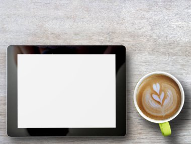 Tablet ve bir fincan kahve ahşap masa arkasında. Kopyalama alanı olan üst görünüm. İş teknolojisi konsepti. Ev fikirlerinden bağımsız ve çalışmalı.