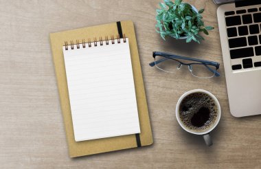 Düz açılı dizüstü bilgisayar klavyesinin yeşil kaktüs fincanı ve boş spiral telif defteri ile çekilmiş üstü görünüm fotoğrafı. Tasarım için boş arkaplanı vardı..