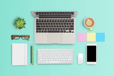 Kahve fincanı, dizüstü bilgisayarı, not defteri, gözlükleri, yeşil masa arkasında akıllı telefonu olan modern çalışma alanı. Düzleştirme biçimi.