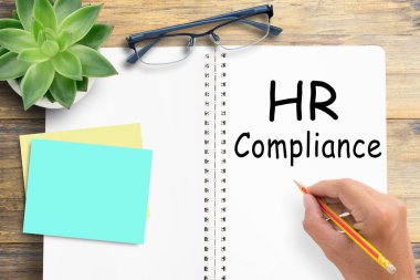 İnsan Kaynakları Uyumu, ofis masasının arkasındaki defterde metin. İş stratejisi, İş ve Finans kavramı.