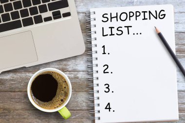 İş yerindeki ahşap masada kahve ve defter ile alışveriş listesi, Yeni Yıl hedefleri ve kararları belirlemek