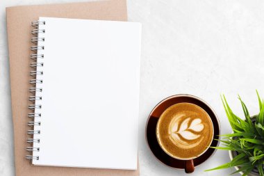 Boş bir defter ya da beyaz ofis masasında duran bir not defteri. Tasarım için kopyalama alanı olan üst görünüm