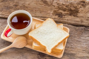 Dilim ekmek ve çay ahşap arka plan üzerinde ahşap plaka