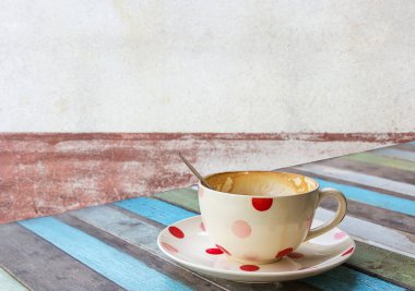 Eski ahşap masa ve bulanıklık arka plan üzerinde kahve fincanı