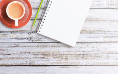 Ofis Masası boş not defteri ve kahve fincanı. Kopya alanı tasarım ile yukarıdan görüntülemek