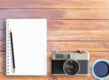 Office ile ahşap masa üst görünümünü sağlar. Ofis resepsiyon masası ile defter, kalem ve vintage fotoğraf makinesi. kopya alanı tasarımı için