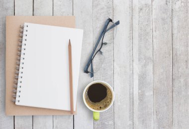 Beyaz ahşap zemin üzerinde boş kağıt defter. Üstten Görünüm kopya alanı (seçici odak) ile. Ofis Resepsiyon Masa kavramı.