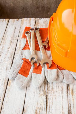 Deri iş eldivenleri ve Beyaz ahşap masa anahtarı ile Emanet şapka