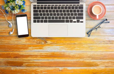 Düz yatıyordu ofis resepsiyon masası fincan kahve, dizüstü bilgisayar, gözlük ve akıllı telefon ile. Kopya alanı ile Üstten Görünüm