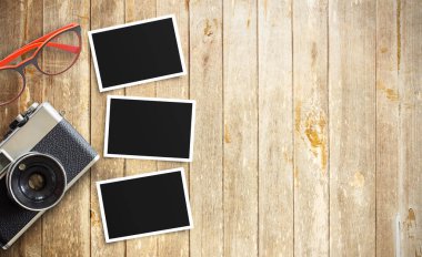 Eski vintage fotoğraf makinesi ve fotoğraf kağıdına ahşap masa üzerinde kırmızı gözlük. Kopya alanı tasarım ile Üstten Görünüm