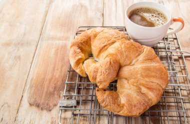 Taze kruvasan ve kahve ızgara ve eski ahşap masa arka plan üzerinde