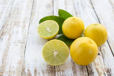 Taze ikiye ayırmak ve arka plan beyaz tahta üzerine bütün limon masa