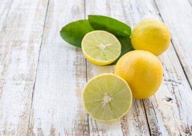 Taze ikiye ayırmak ve arka plan beyaz tahta üzerine bütün limon masa