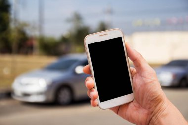 Bulanık arkaplanı olan akıllı telefonu tutan