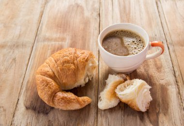 Kruvasan ve kahve eski ahşap masa günü kahvaltıda