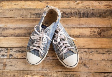 Bir ahşap zemin üzerinde kirli eski Ayakkabı