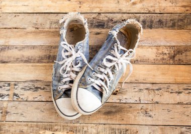 Bir ahşap zemin üzerinde kirli eski Ayakkabı