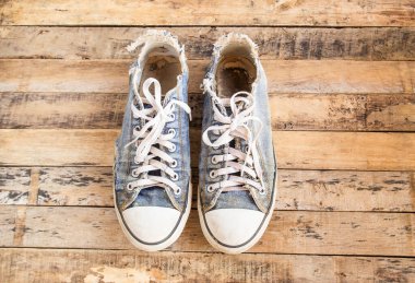 Bir ahşap zemin üzerinde kirli eski Ayakkabı