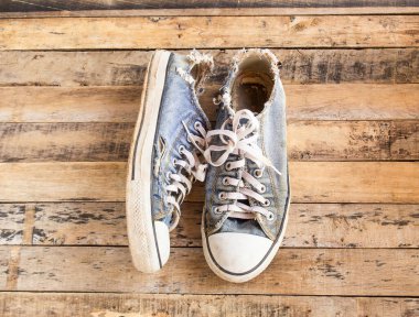 Bir ahşap zemin üzerinde kirli eski Ayakkabı