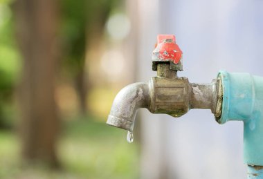 Arka planda bulanık bir musluk suyuna yakın. tasarım için boşluk kopyala