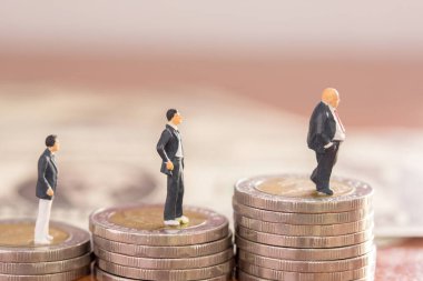 Minyatür insanlar: işadamı rakamlar ayakta madeni para ile arka plan bulanık. para ve mali kavramı. kopya alanı iş arka plan veya duvar kağıdı olarak kullanmak için.