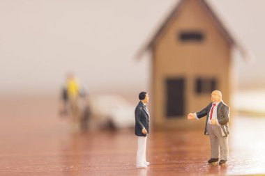 Minyatür insanlar: işadamı rakamlar bulanık kağıt evin arka plan ile zemin üzerinde duran. para ve mali kavramı. kopya alanı iş arka plan veya duvar kağıdı olarak kullanmak için.