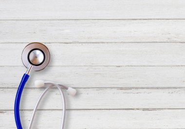 Ofisteki beyaz ahşap masada mavi steteskoplu üst manzara. Metin ya da tasarımınız için boşluk.