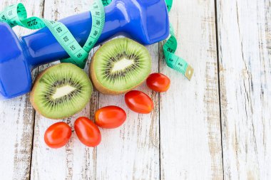 Taze kivi, halter ve Beyaz ahşap masa arka plan üzerinde kırmızı domates