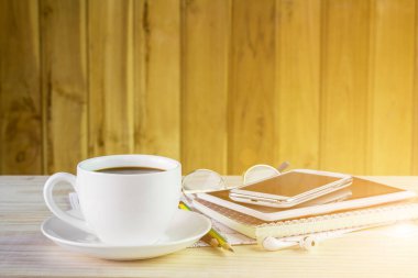 Ahşap masa arka plan üzerinde not defteri ile kahve fincan. İş kavramı