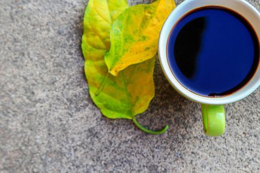 Üstten görünüm fincan kahve çimento katta sonbahar yaprakları ile