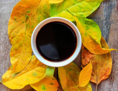 Eski ahşap masa üzerinde sonbahar yaprakları ile kahve fincan üstten görünüm