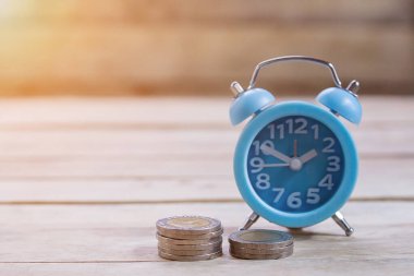 Paralar, alram saat ve kalem ile ahşap masa arka plan üstünde boş defter. Ofis Masası para sikke ve iş finansal planlama kavramı ile