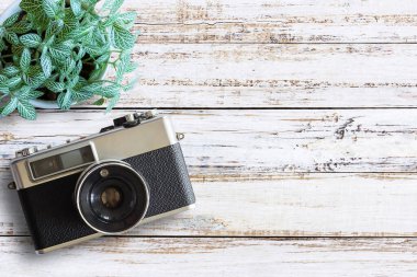 Ofis Resepsiyon ahşap masaları ile vintage fotoğraf makinesi ve taze çiçek. Üstten Görünüm kopya alanı ile. Üst eski fotoğraf makinesi Beyaz ahşap masa üzerinde görüntüleyin. Retro vintage filtre.