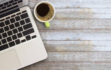 Laptop bilgisayarı ve kahve fincanının kahverengi ahşap masa zemininde en üst görünümü. Eğitim için duvar kağıdı, iş fotoğrafı kullanılıyor. Kitap için kağıt ve konsept, nesne ya da boşluk kopyası içeren ürünü not alın..