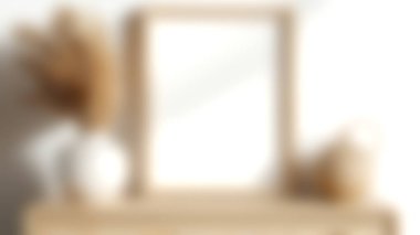 Boş bir çerçeve, kurumuş bitkilerle süslü şık bir vazo ve sadeliği ve zarif tasarımı yansıtan ahşap bir masa sunan güzel bir minimalist dekor..