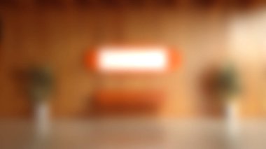 Gösterişli, minimalist, portakal rengi duvar sanatıyla tamamlanmış ahşap duvarlar. Mekanda şık bir bank ve yemyeşil bitkiler var, davetkar bir atmosfer yaratıyorlar..