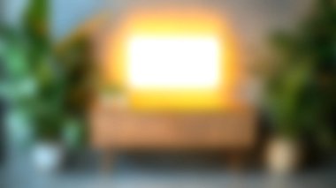 Zarif ahşap bir dolap, canlı bitkiler ve aydınlatılmış bir çerçeve içeren güzel düzenlenmiş bir yaşam alanı, sıcak ve davetkar bir atmosfer yaratıyor..