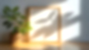 Tahta bir masanın üzerinde minimalist boş bir çerçeve sergilenen sakin bir sahne, yapraklı bir bitki aksanlı. Yumuşak gölgeler, doğal ışıkla dolu davetkar bir atmosfer yaratır..