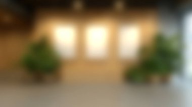 Üç boş çerçeveli, canlı yeşil bitkilerle çevrili ahşap bir duvarın yer aldığı geniş bir kapalı alan. Modern tasarım ve dekorasyon için mükemmel..