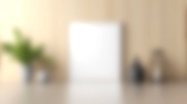 Bu resim, boş bir çerçeve, saksı bitkisi ve pürüzsüz bir masa üstünde dekoratif nesnelerle modern bir minimalist iç mekan içerir. Tarafsız renkler sakin bir atmosfer yaratır..