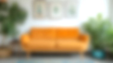 Bu resim, canlı turuncu bir kanepe, yeşil bitkiler ve ev dekorasyonu fikirleri için mükemmel olan zevkli duvar sanatının yer aldığı şık bir orta çağ modern oturma odasını gösteriyor..